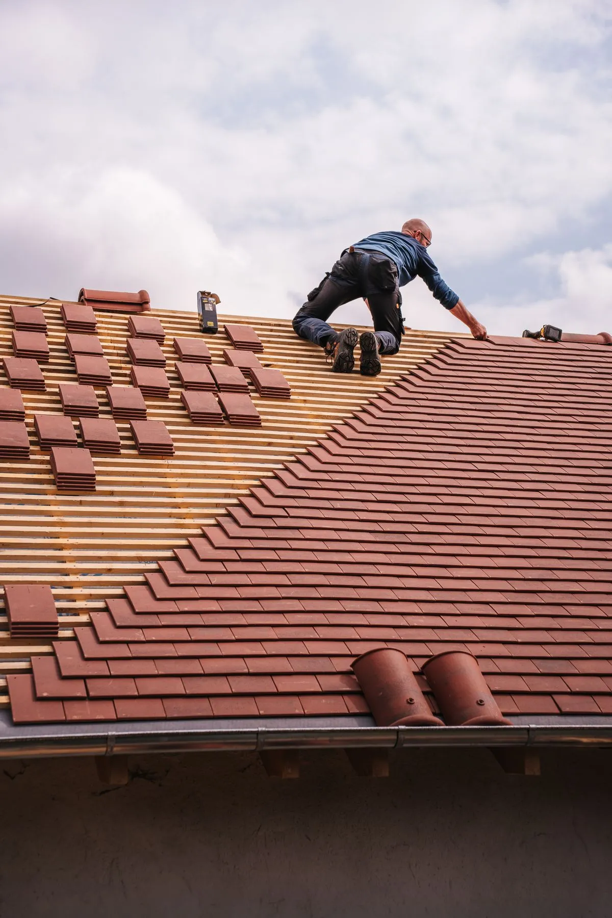 Roofer installing tiles on a residential roof